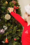 Festive little girl hanging a christmas decoration