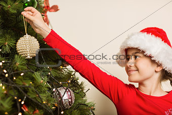 Festive little girl hanging a christmas decoration