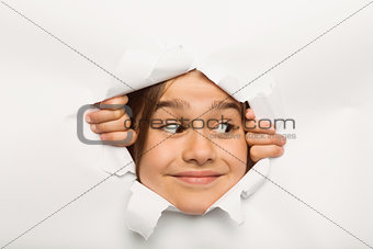 Cute little girl peeking through paper