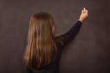 Cute pupil writing on chalkboard