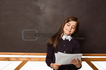 Cute pupil holding white pages