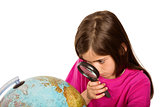 Cute pupil looking at globe through magnifying glass