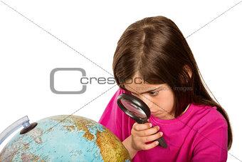 Cute pupil looking at globe through magnifying glass