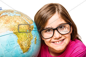 Cute pupil smiling at camera with globe
