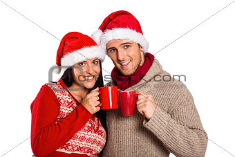 Young festive couple holding mugs
