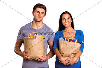 Young couple holding grocery bags