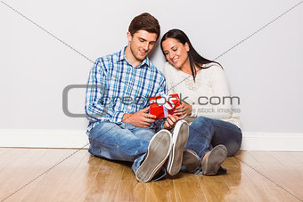 Young couple sitting on floor with gift