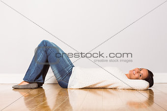 Young woman lying on floor smiling