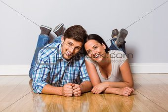 Young couple lying on floor smiling