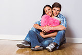 Young couple sitting on floor smiling