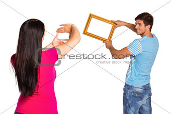 Young couple hanging a frame