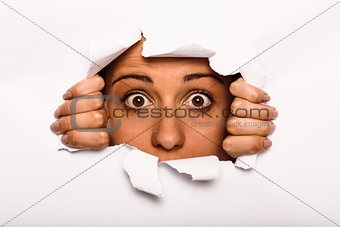 Young woman looking through paper rip