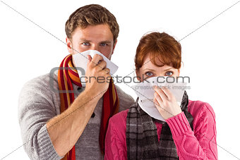 Couple blowing noses into tissues
