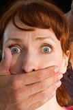 Terrified woman with covered mouth