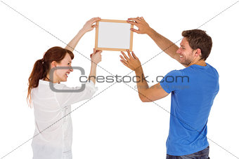 Couple hanging picture on wall