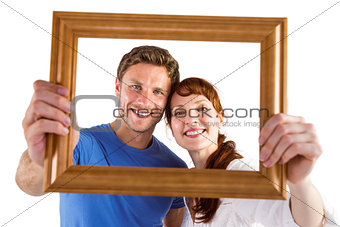 Couple holding frame ahead of them