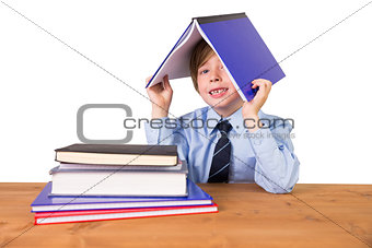 Student covering head with book