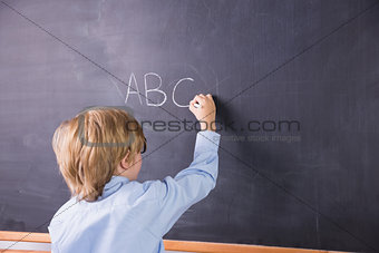 Student writing on large blackboard