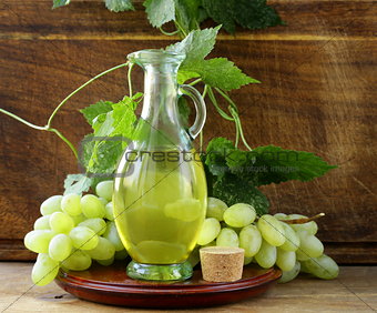 jugful with grape seed oil on a wooden table