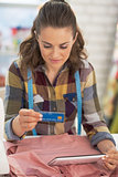 Portrait of tailor woman with credit card using tablet pc at wor