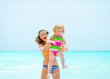 Portrait of smiling mother and baby girl on beach