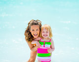 Portrait of smiling mother and baby girl at seaside