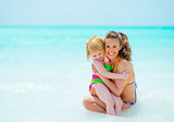 Portrait of mother and baby girl on sea shore