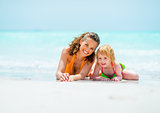 Portrait of mother and baby girl relaxing on sea coast