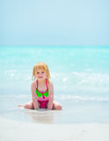 Portrait of baby girl sitting on sea coast