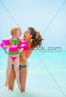 Portrait of smiling mother and baby girl in sea