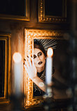 Mysterious portrait of beautiful goth girl looking into mirror