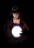 Attractive witch or fortune teller looking into a crystal ball 