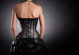 Back view of woman in silver leather corset 