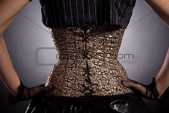 Back view of woman wearing golden corset 