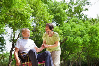 Asian senior man sitting on a wheelchair with his wife