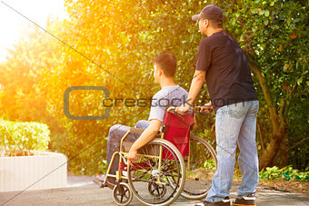 young man sitting on a wheelchair with his brother