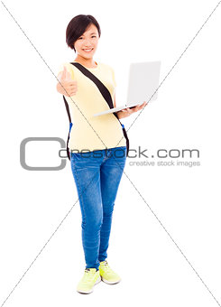 Smiling young woman holding a laptop and thumb up