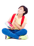  young student girl sitting on floor with book and thinking