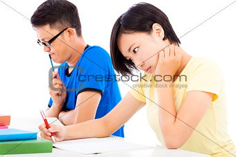 two college students sitting an exam in a classroom