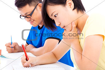 two young students exams together in classroom