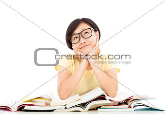 smiling young student girl thinking with book on the desk