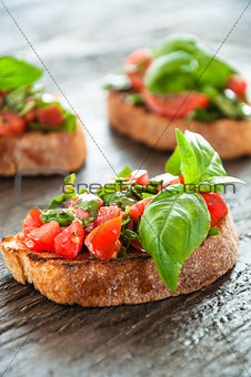 Italian tomato bruschetta with chopped vegetables, herbs and oil on grilled or toasted crusty ciabatta