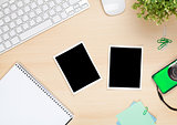 Photo frames on office table with notepad, computer and camera