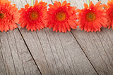 Wooden background with orange gerbera flowers