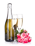 Champagne bottle, two glasses and red rose flowers