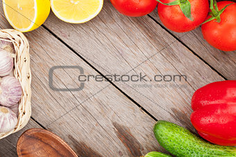 Fresh ripe vegetables and utensils on wooden table