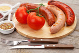 Various grilled sausages with condiments and tomatoes
