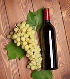 Red wine bottle and bunch of white grapes