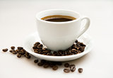 Cup of coffee and beans over white background