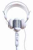 White vintage microphone and headphones over white background